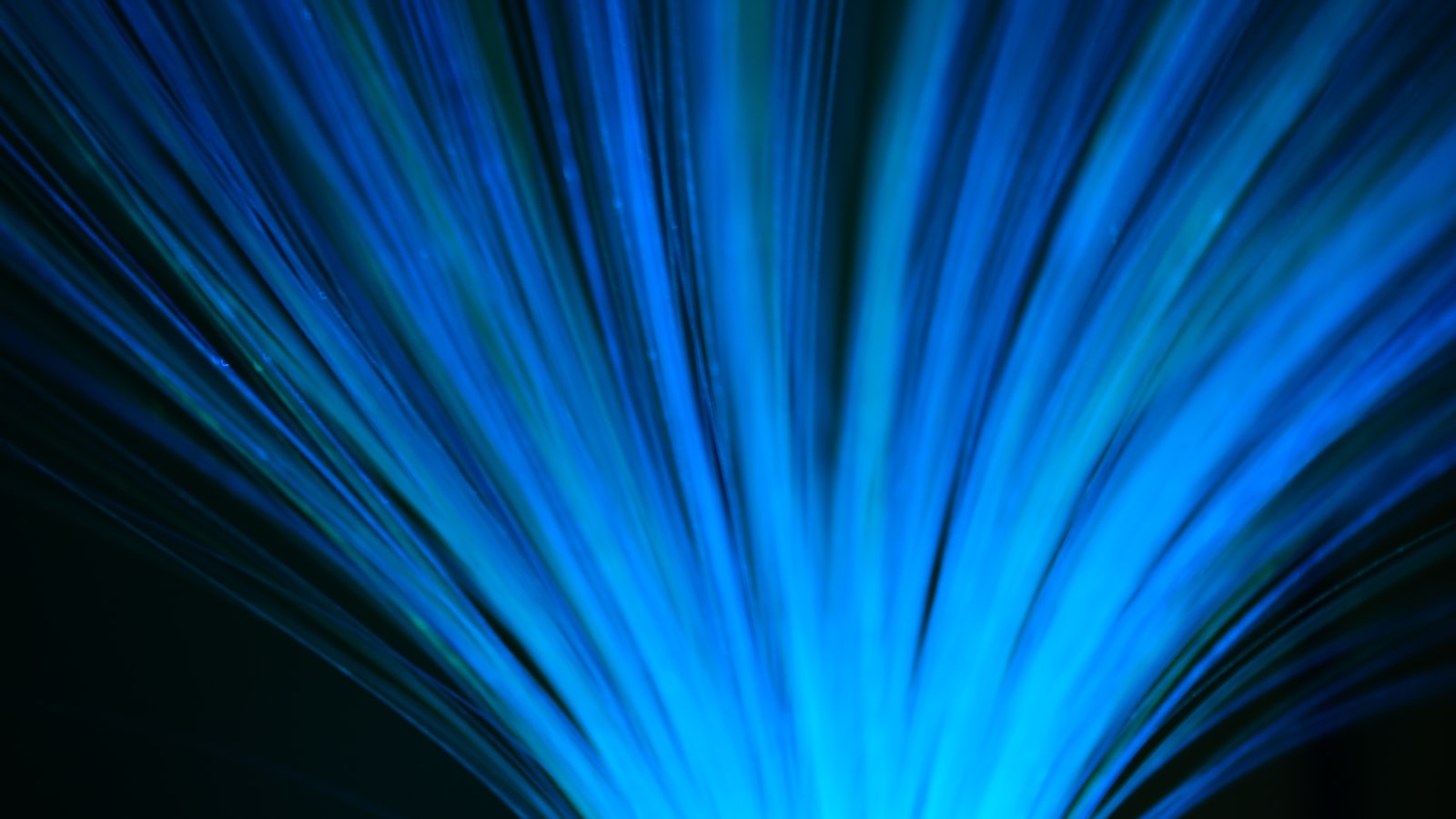 Blue fiber-optic strands glowing against a dark background
