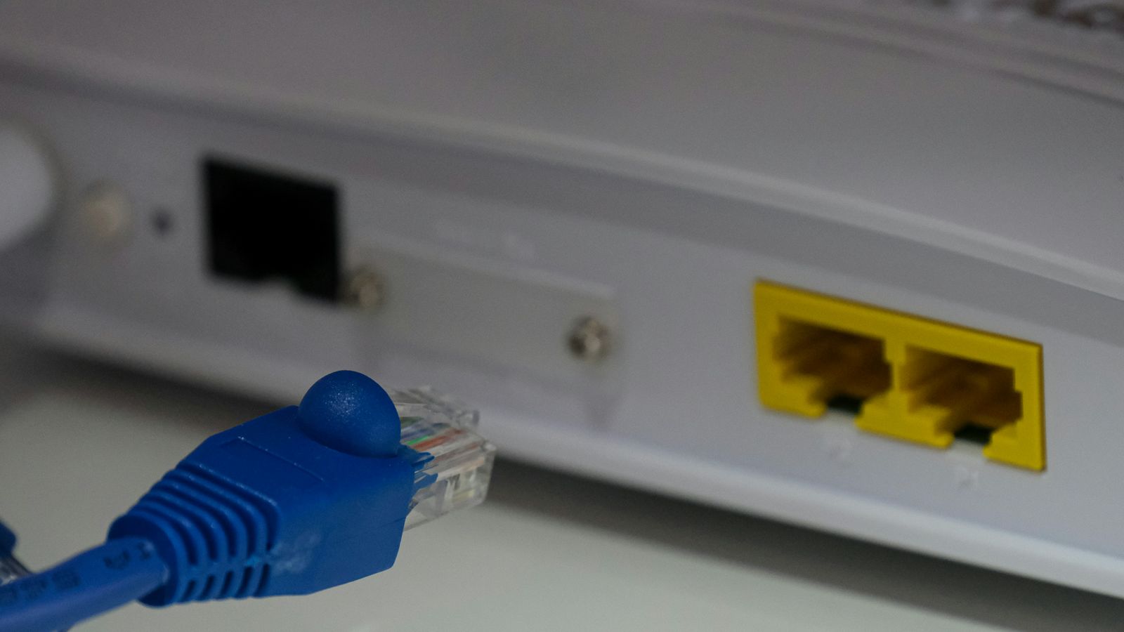 Disconnected blue Ethernet cable in front of empty router network ports